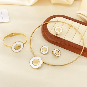 Exquisite gold stainless steel jewelry set with white round resin on silk background