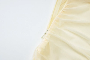 Detail view of the invisible zipper closure and fine mesh stitching on this cream dress