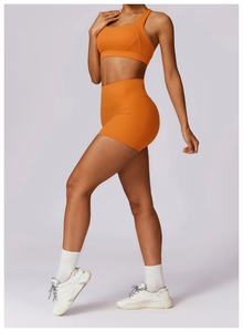 Detail view of bright orange yoga set with seamless high-waist shorts and racerback tank top
