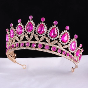 Macro detail of gold bridal crown featuring pink teardrop gems and sparkling rhinestones