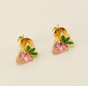 Detail of gold strawberry stud earrings with pink heart crystal and green marquise gems