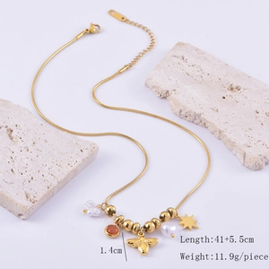 Detailed view of bee and pearl charms on a golden snake chain with dimension markers
