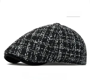 Close-up of black and white houndstooth pattern and knit texture on the newsboy cap