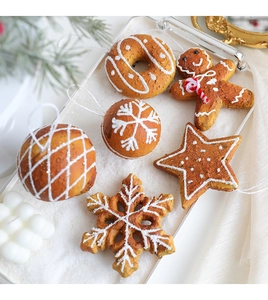 Detail of gingerbread man and snowflake foam ornaments on a white tray for Christmas tree deco