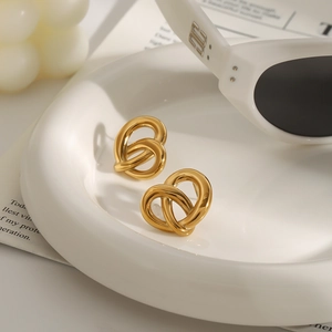 Elegant 18k gold plated stainless steel twisted heart earrings on a stylish white tray