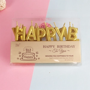 Close-up of gold Happy Birthday letter candles in elegant English window packaging