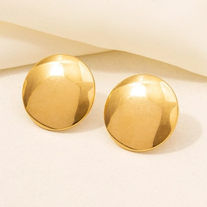 Macro detail of high-shine gold round stud earrings with mirror polished finish