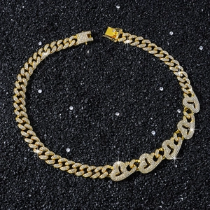 Detail of gold Cuban chain necklace with sparkling rhinestones and heart link design