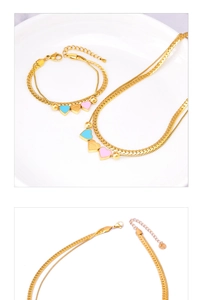 Detail of gold double-layer snake chain with pink and blue heart pendants and engraving
