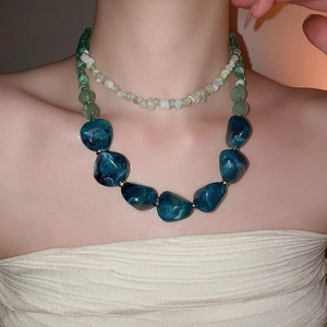 Close-up of double-layer necklace with blue marble acrylic beads and white stone accents