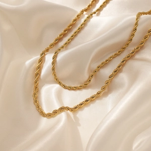 Elegant 4mm gold-tone stainless steel rope chain necklace on champagne silk background