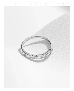 Detailed view of silver stackable ring featuring alternating square and round zircons
