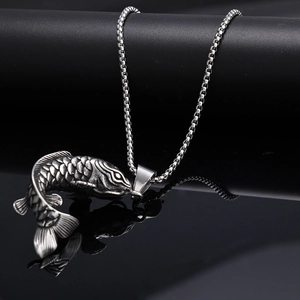 Macro shot of polished stainless steel koi fish pendant with detailed scales and box chain