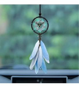 Detail of dreamcatcher car mirror pendant with bronze stag head and blue gradient feathers