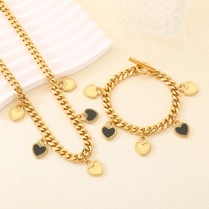 Détail du collier et bracelet cubain plaqué or 18K avec breloques en forme de cœur noir