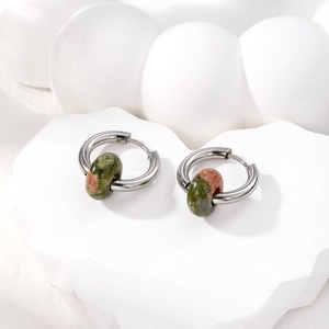Macro detail of stainless steel hoop earrings featuring natural unakite stone beads
