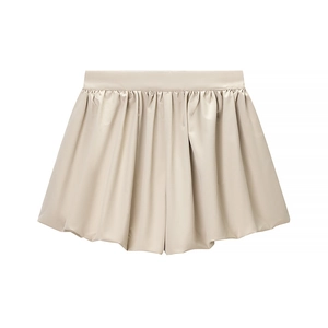 Macro detail of beige satin pleated skort showing glossy texture and elegant folds