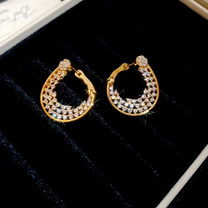 Gros plan de boucles d'oreilles créoles plaquées or 18K serties de zircons cubiques