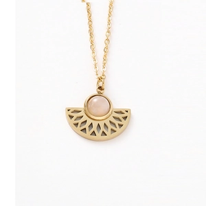 Detailed macro view of fan-shaped gold pendant necklace with carved lines and center stone