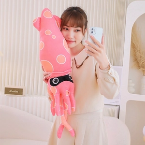 Pink plush squid toy with orange spots held by a model in a cozy living room setting