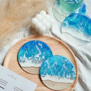 Detail eines runden Harz-Untersetzers mit blauem Meereswellen-Design auf Holztablett