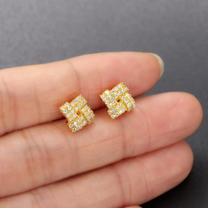 3D sugar-cube gold earrings set with micro-inlaid zircons shown on a finger for size