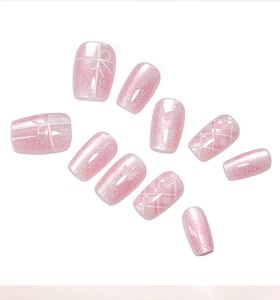 Detail of pink cat-eye press-on nails with butterfly motifs and diamond lattice patterns