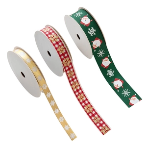 Three rolls of Christmas ribbons with gold snowflakes and Santa patterns for gift wrapping