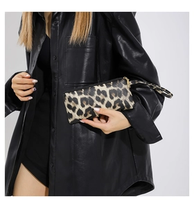 Detail of leopard print wristlet clutch with metal zipper and matching strap held by model