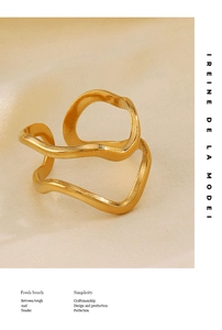 Detail of a wavy gold irregular open ring on a textured beige fabric background