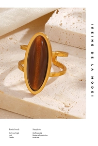 Detailed view of a vintage gold oval tiger eye ring set against a textured stone backdrop