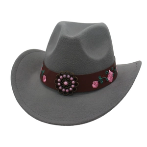 Detail of grey felt cowboy hat featuring pink floral embroidery and a copper metal floral ornament