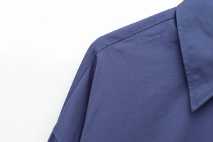 Detail of the navy blue shirt collar and shoulder with high-quality woven fabric texture