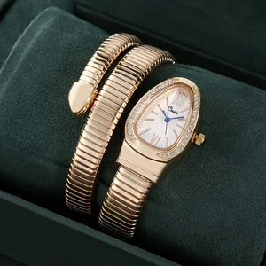 Close-up of rose gold snake bracelet watch featuring a rhinestone bezel and blue needles