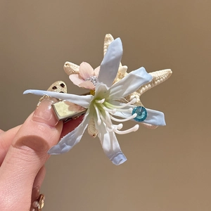 Detail of fabric flower hair clip with starfish decor and rhinestone on silver alligator clip