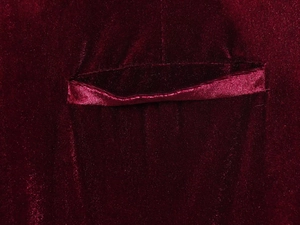 Detailed close-up of the welt pocket on a high-quality deep red velvet blazer fabric
