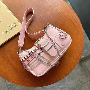 Detailed top view of pink Y2K baguette bag with silver chain and heart charm on wood