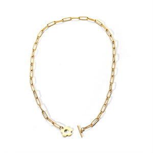 Close-up of gold paperclip chain necklace featuring a flower toggle and T-bar clasp