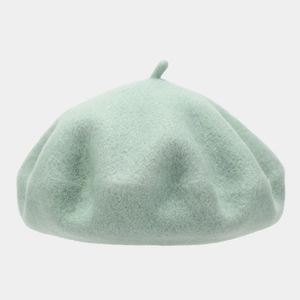 Detail shot of mint green wool felt beret showing thick fiber texture and top stem