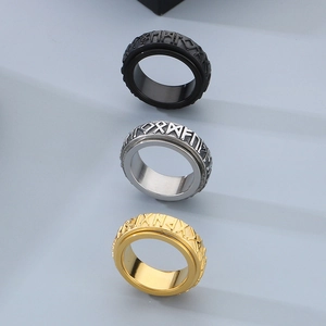 Close-up of rotatable Viking rune rings in black, silver and gold stainless steel