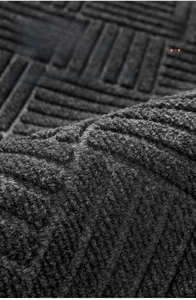 Detailed macro view of the 3D grooved texture on a gray anti-slip entrance doormat