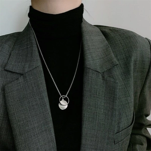 Hip hop style silver necklace featuring double geometric circle pendants on a male model