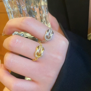 Macro detail of linked double rings with pave zircon and delicate gold chain connectors