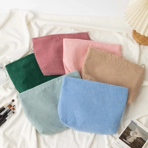 Corduroy large capacity cosmetic bags in various colors displayed on a white fabric surface
