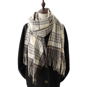Plaid cashmere-like scarf in beige and brown with fringes on a model in black coat