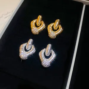Orecchini a cerchio intrecciati in oro e argento con pavé di diamanti su velluto nero