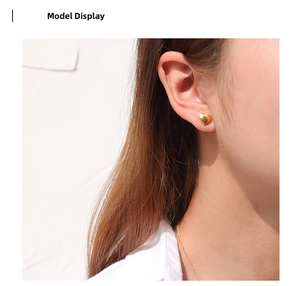 Close-up model shot of elegant gold heart-shaped stud earrings with polished finish