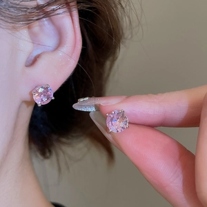 Detailed view of pink zircon stud earrings featuring a classic round cut and silver prongs