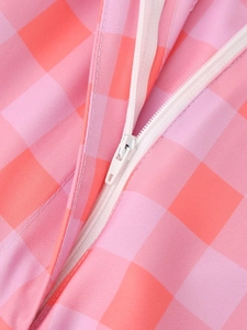Close-up detail of pink and orange plaid fabric with high-quality white zipper closure