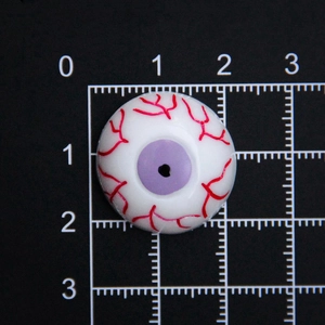 Détail macro d'un œil en résine violette de 20mm avec veines rouges sur grille noire